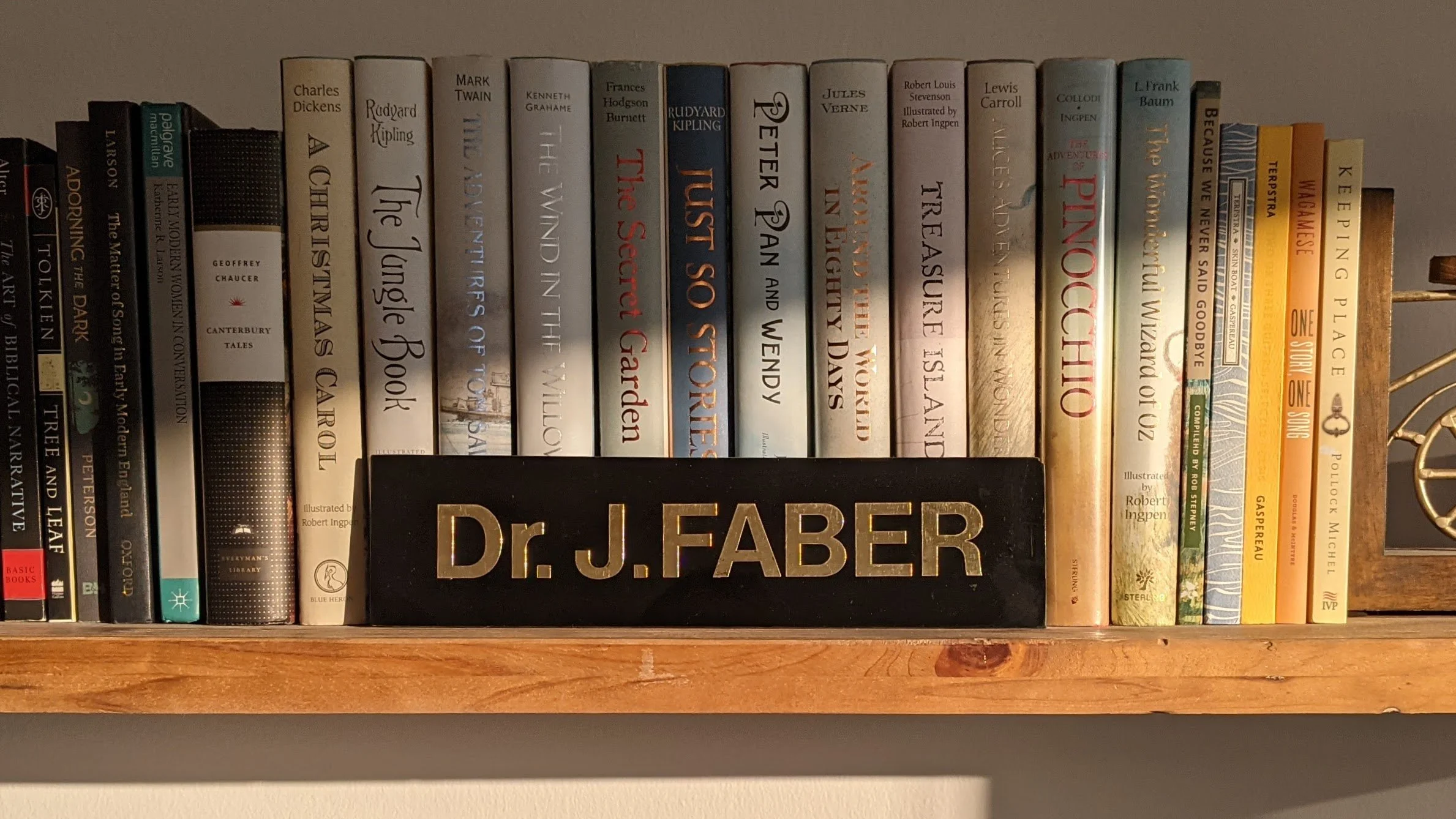 A desk nameplate reading Dr. J. Faber, on a shelf of books